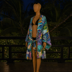 Mannequin wearing a colorful kimono-style garment with a tropical background