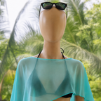 Mannequin wearing a turquoise cover-up and black sunglasses with a tropical background